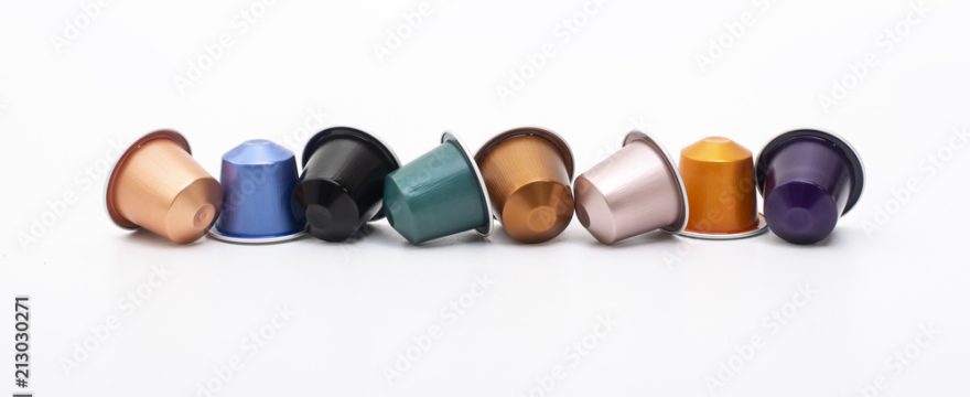 lined up coffee capsules on white background